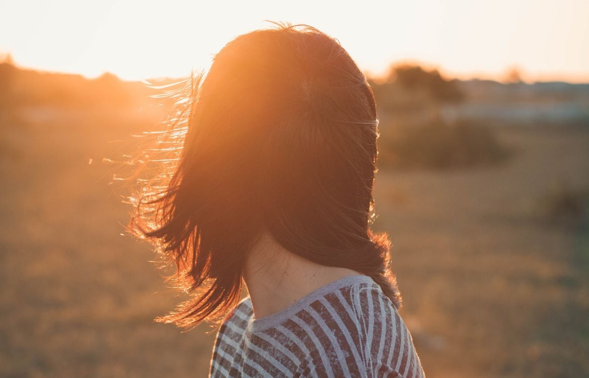 girl-looking-at-sunset-in-field