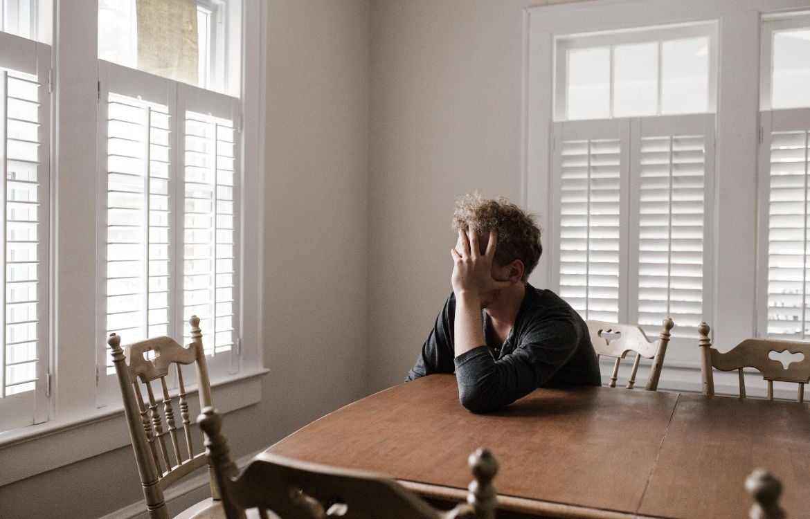 man-at-table-with-head-in-hands