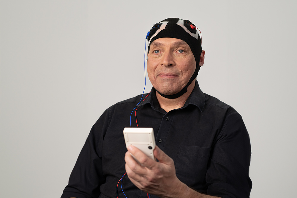 2024_Mann-mit-Haube-und-DC-STIMULATOR-MOBILE