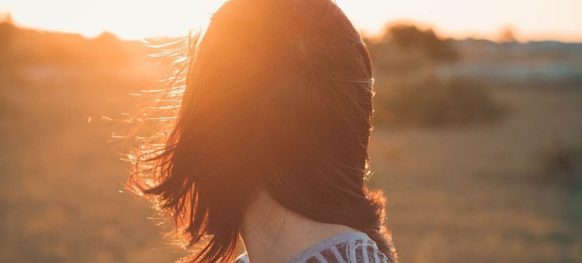 girl-looking-at-sunset-in-field