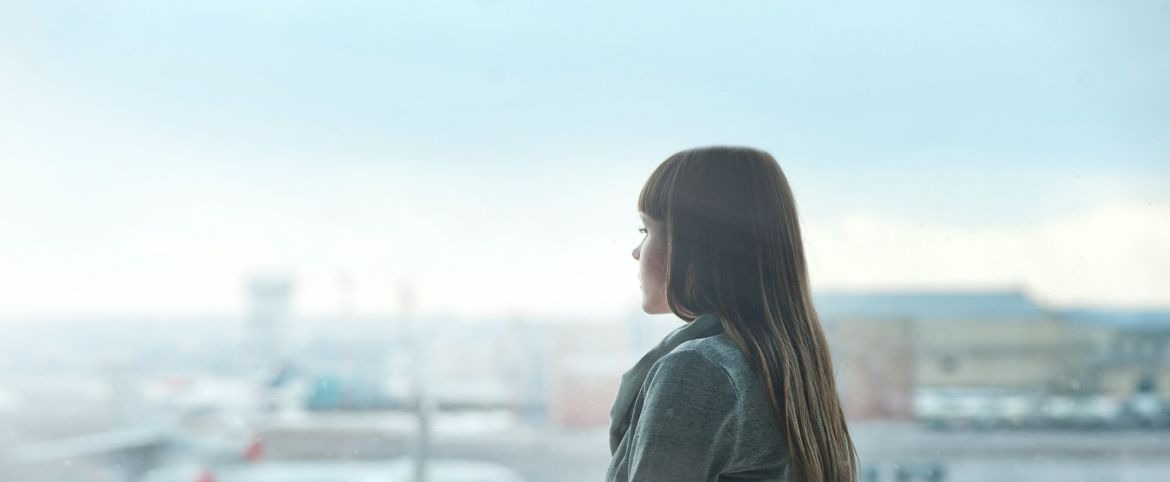 woman-at-airport-looking-out-the-distance