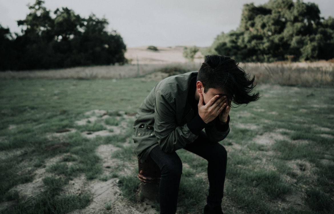 young-man-in-nature-head-in-hands